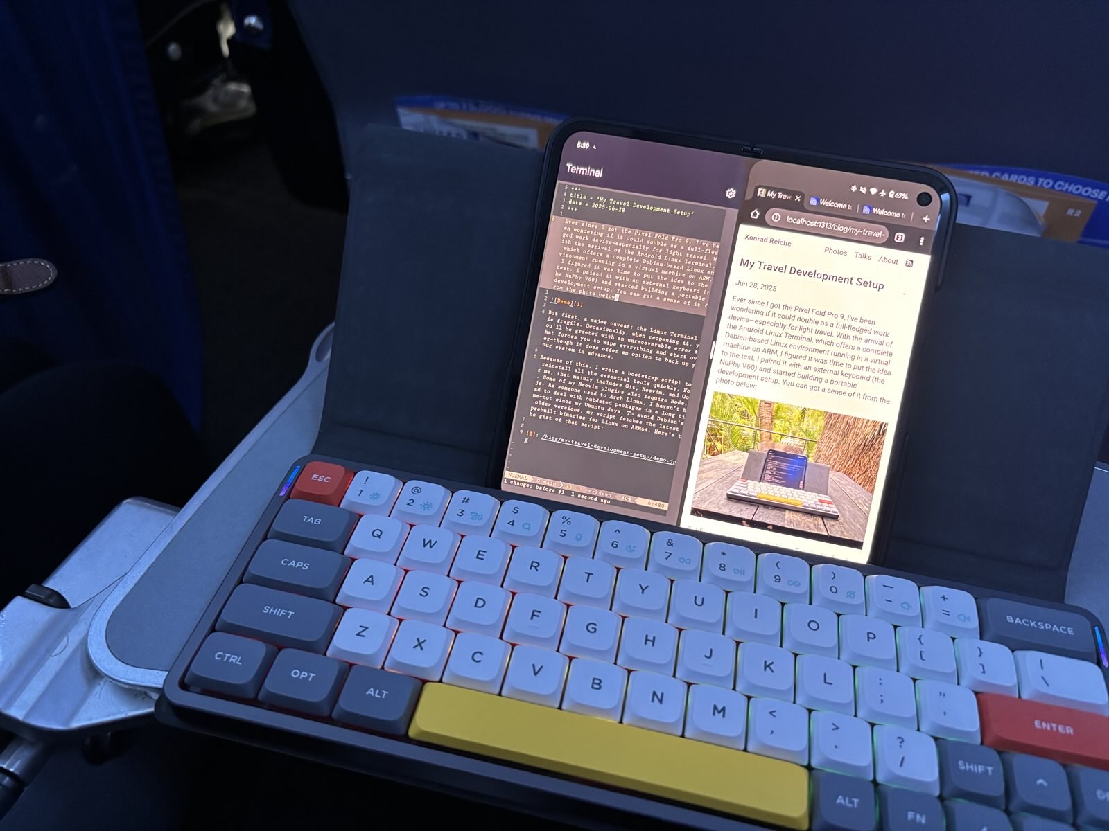 Pixel Fold in split-screen mode showing a terminal and browser side by side, running a blog preview, with a NuPhy keyboard set up on an airplane tray table.
